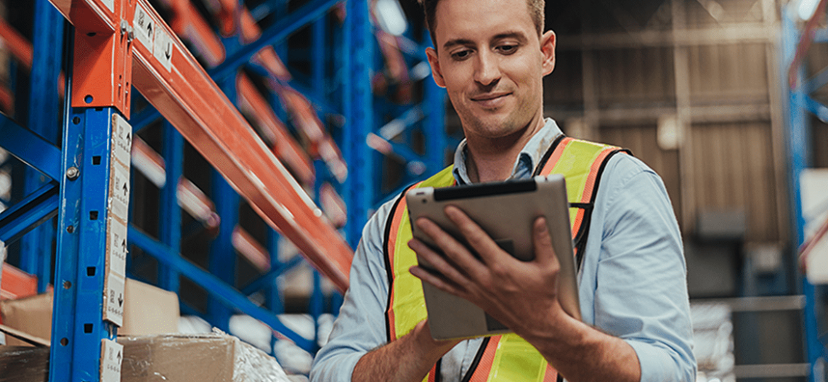 distribution case study man in safety PPE vest using an ipad in facility